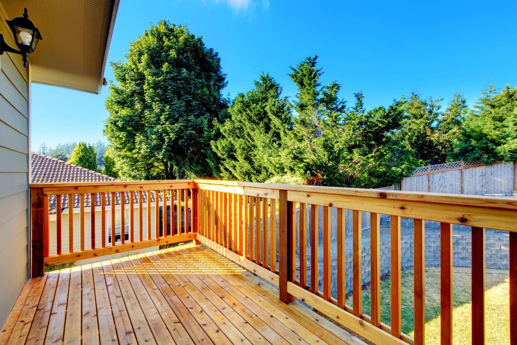 A freshly stained wood deck with railings